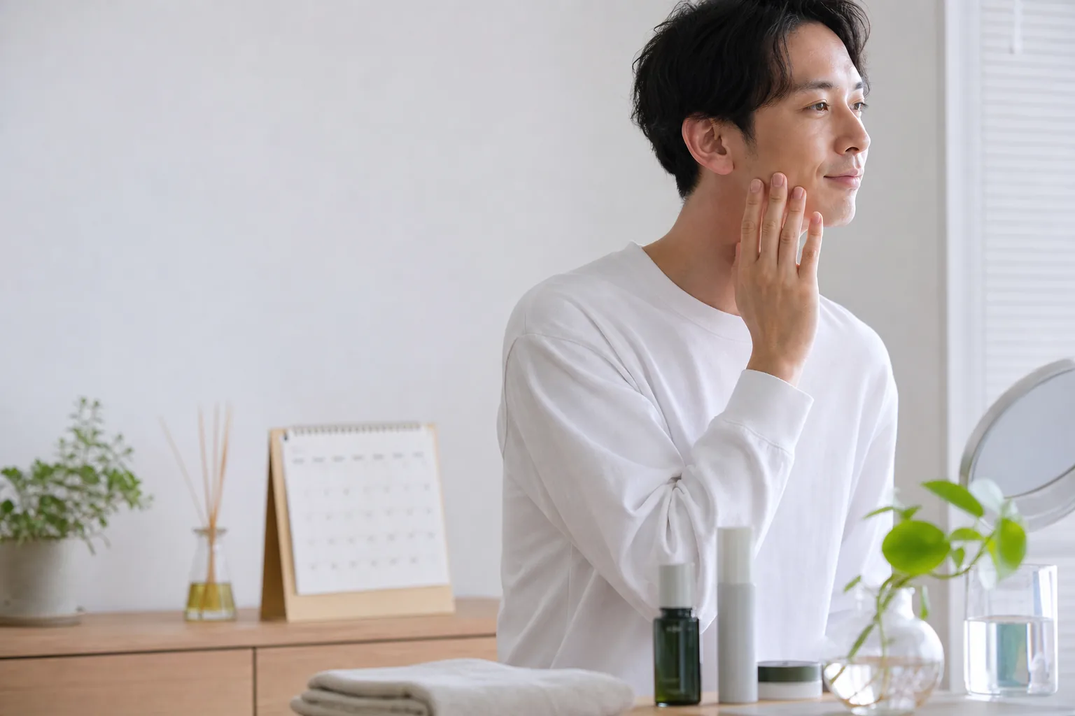 朝の自然光の中、鏡の前で日々のケアを続ける成人男性